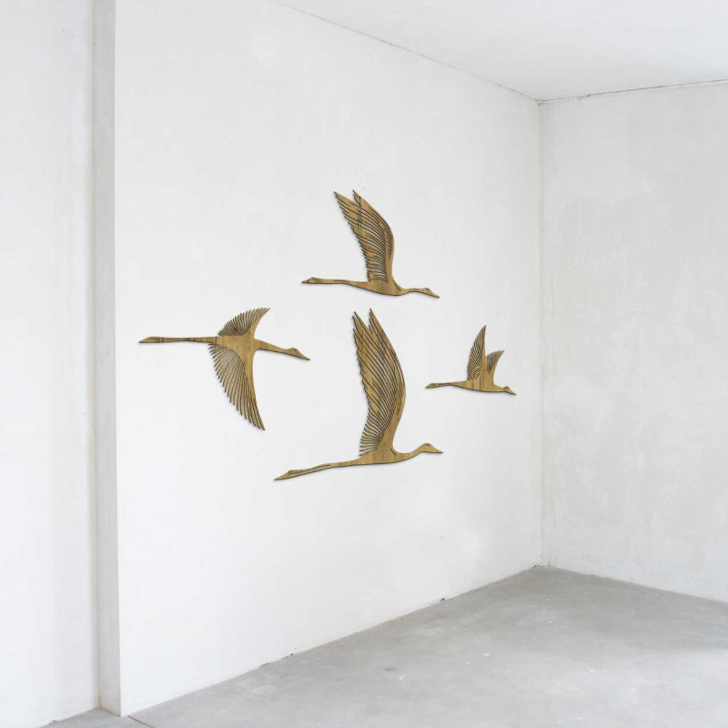 Holzmotiv von vier nach rechts fliegenden Vögeln