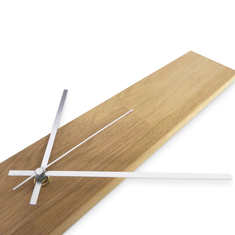 Minimalistische Uhr mit Holzsockel und schwarzen Zeigern, ohne Zahlen.