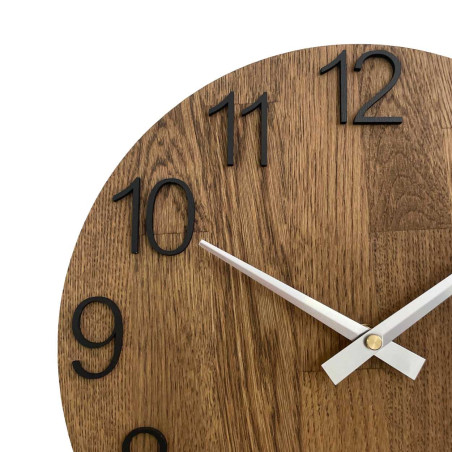 Runde Uhr mit dekorativem Ausschnitt in der Mitte und zartem Holzmuster. Runde Uhr mit dekorativem Ausschnitt in der Mitte und zartem Holzmuster.