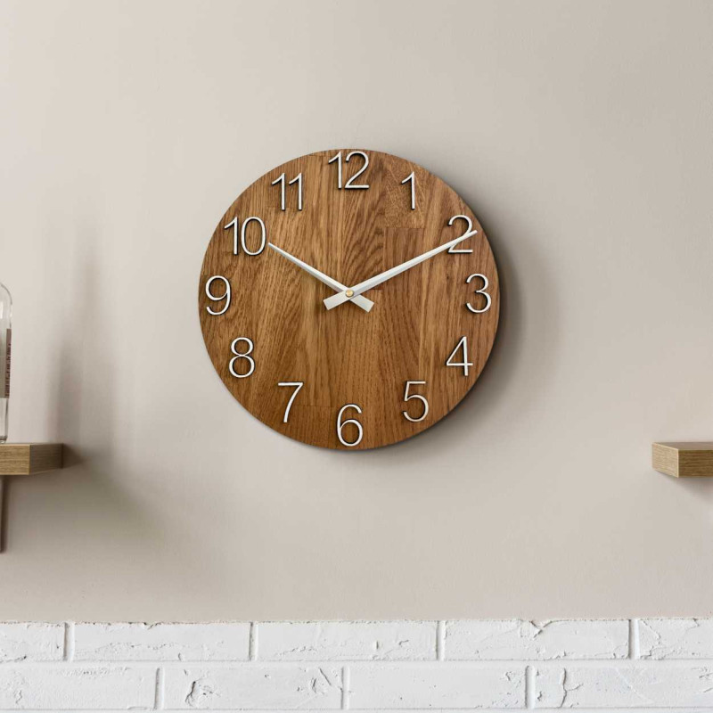 Wanduhr aus Holz mit runder Form und dezentem Naturmotiv.