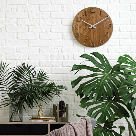 Runde Uhr mit dekorativem Ausschnitt in der Mitte und zartem Holzmuster. Runde Uhr mit dekorativem Ausschnitt in der Mitte und zartem Holzmuster.